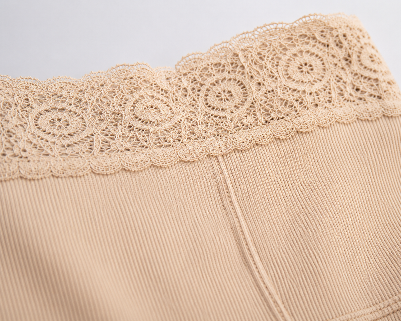 Beige fabric with lace trim on a light gray background